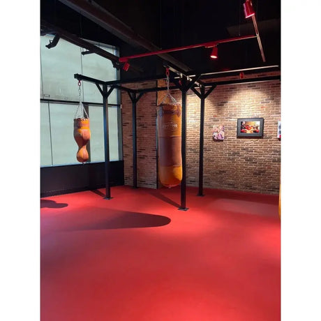 SportCom Proboxe Wandstation für Sandsäcke, auf rotem Boden vor Backsteinwand