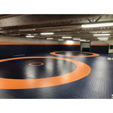 SportCom Ringerkreis-Aufdruck für Dollamur Flexi-Roll-Matten: blaue Matte mit orangen Kreisen in einer großen Halle