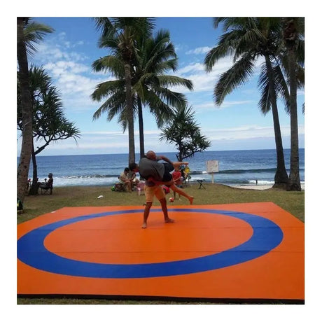 SportCom Ringerkreis-Aufdruck für Dollamur Flexi-Roll-Matten: orange Matte mit blauem Ring im Freien, zwei Ringer am Strand