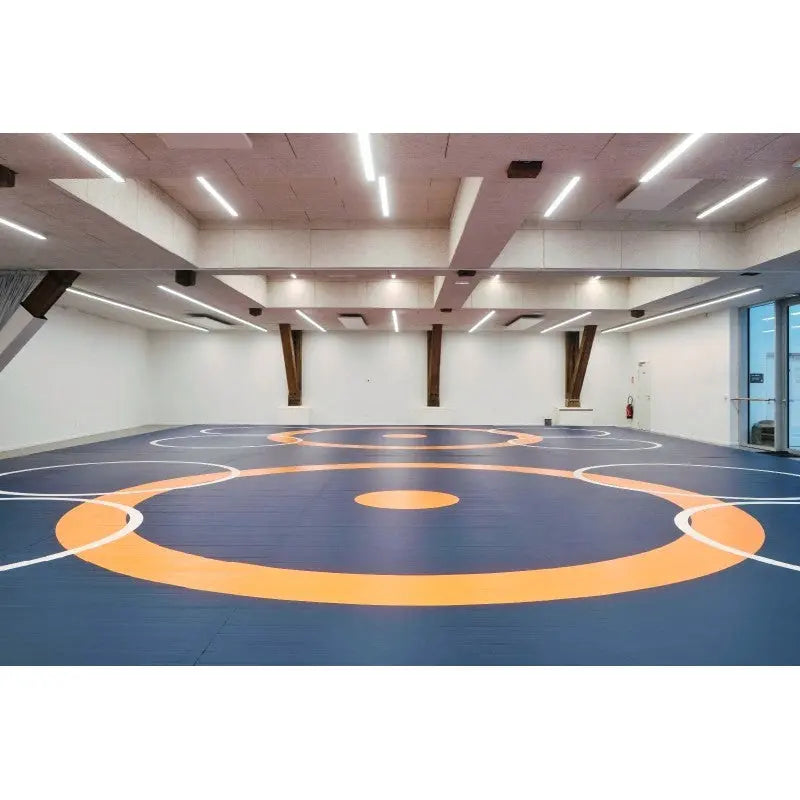 SportCom Ringerkreis-Aufdruck für Dollamur Flexi-Roll-Matten: blaue Matte mit orangem Kreis in einer hellen Sporthalle