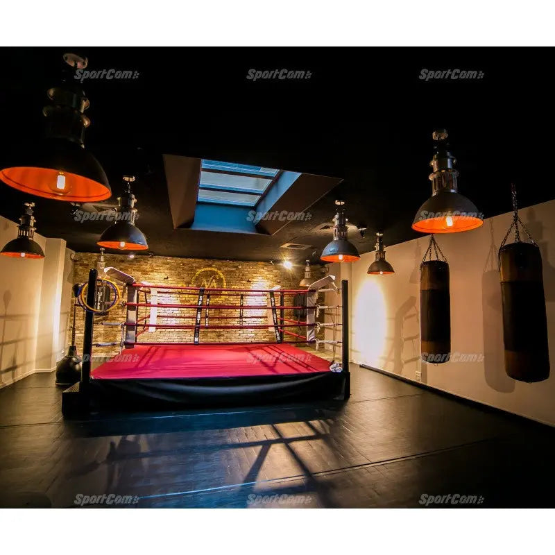 SportCom Ringplane für Wettkampf-Boxringe: Ring mit roter Plane in einem Gewölbekeller mit Boxsäcken