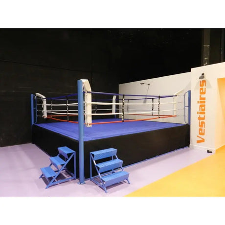 SportCom Ringplane für Wettkampf-Boxringe: Ring mit dunkelblauer Plane und zwei Treppen vor Umkleiden