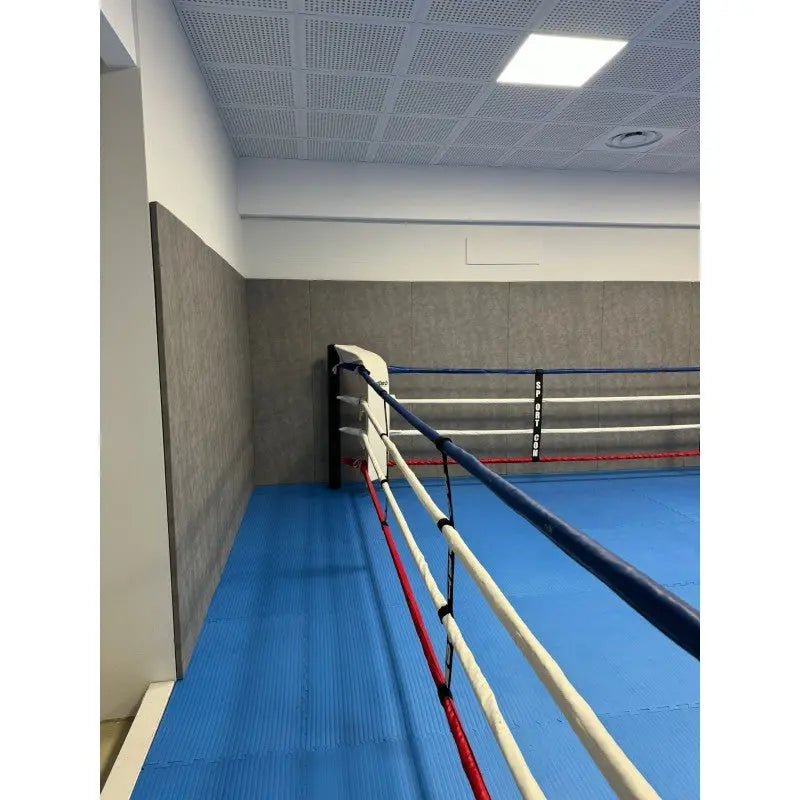 SportCom Wettkampf-Boxringseil mit Hülle, Ringseile an der Wand über blauem Boden, seitliche Ansicht