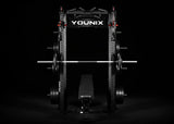 Younix Cable Rack Kabelzug-Power-Rack in Schwarz, Frontansicht mit Langhantel und Hantelbank vor dunklem Hintergrund