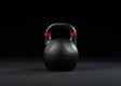 Younix Competition Kettlebell Full Set, einzelne schwarze Kettlebell mit rotem Griffband vor dunklem Hintergrund