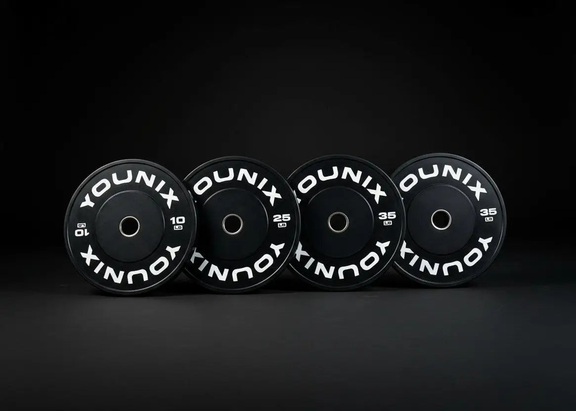 Younix Premium Bumper Set 100 kg Hantelscheiben-Set, vier schwarze Scheiben stehend vor dunklem Hintergrund